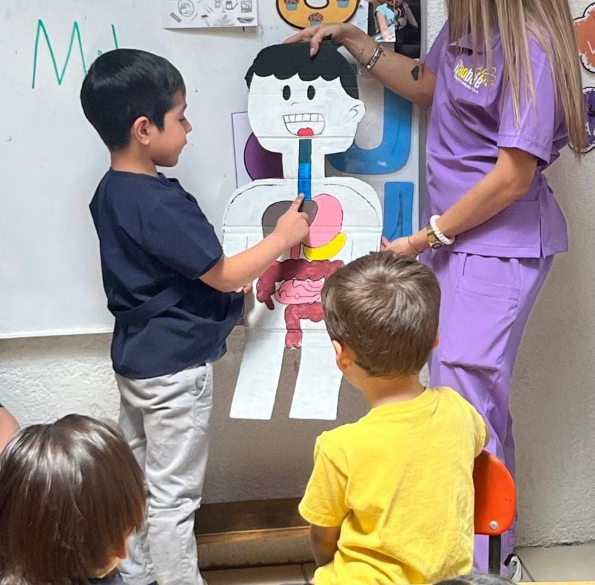 Niño explicando las partes del cuerpo humano frente a sus compañeros