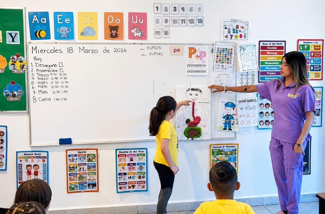 Maestra acompañando de cerca a una niña durante su clase